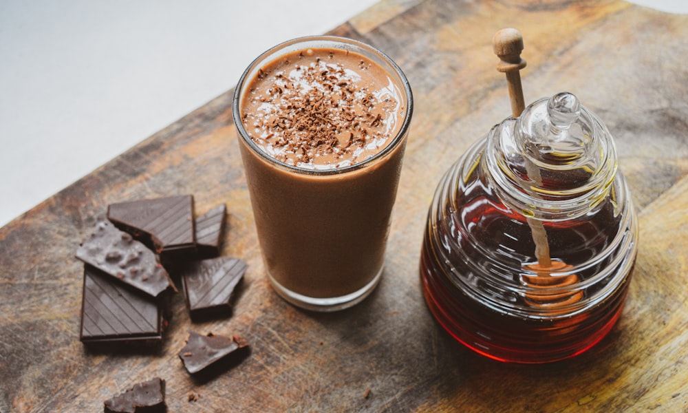 A dark, rich chocolate pistachio smoothie in a glass jar.