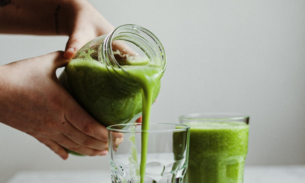 A minimalist, beautiful glass of matcha with a thick creamy layer of foam on top.
