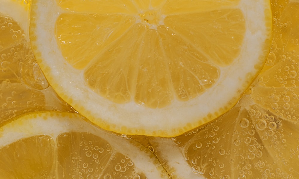 Glass of chia seed lemon drink with fresh lemon slices and a metal straw on a bright sunny kitchen counter