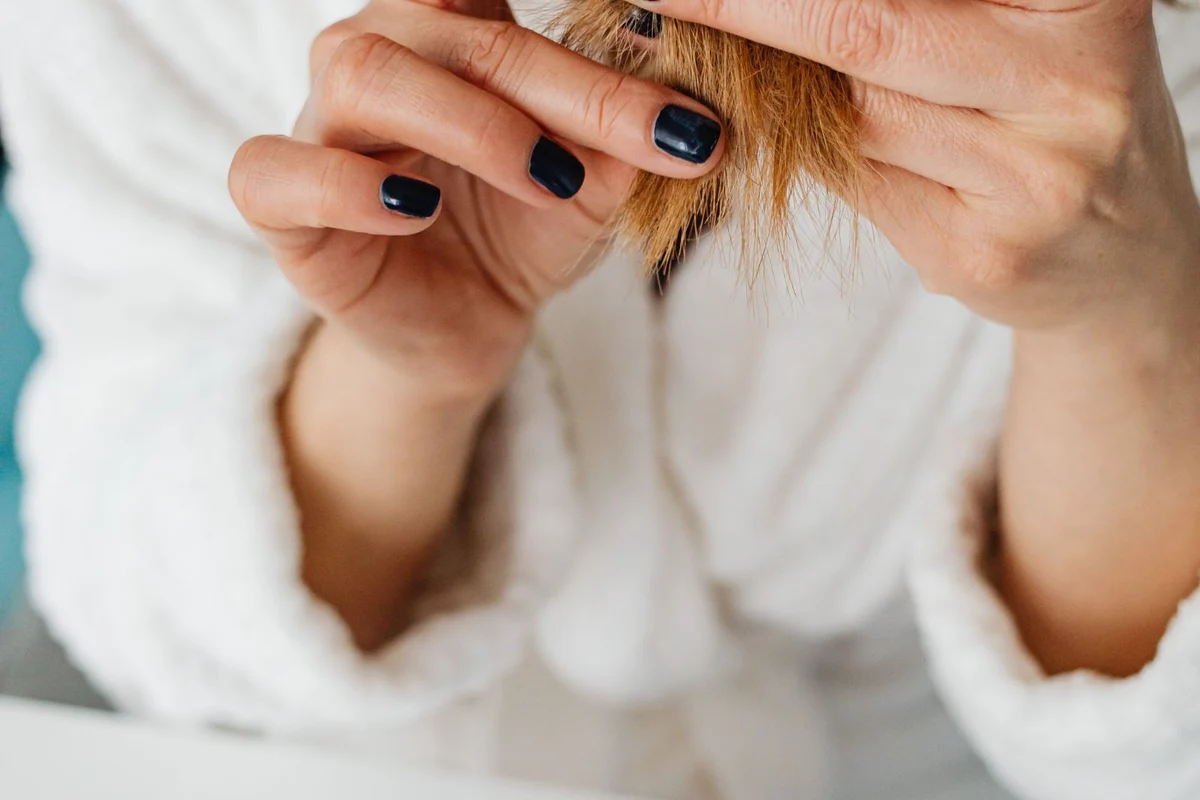 Woman examining the dry ends of her hair