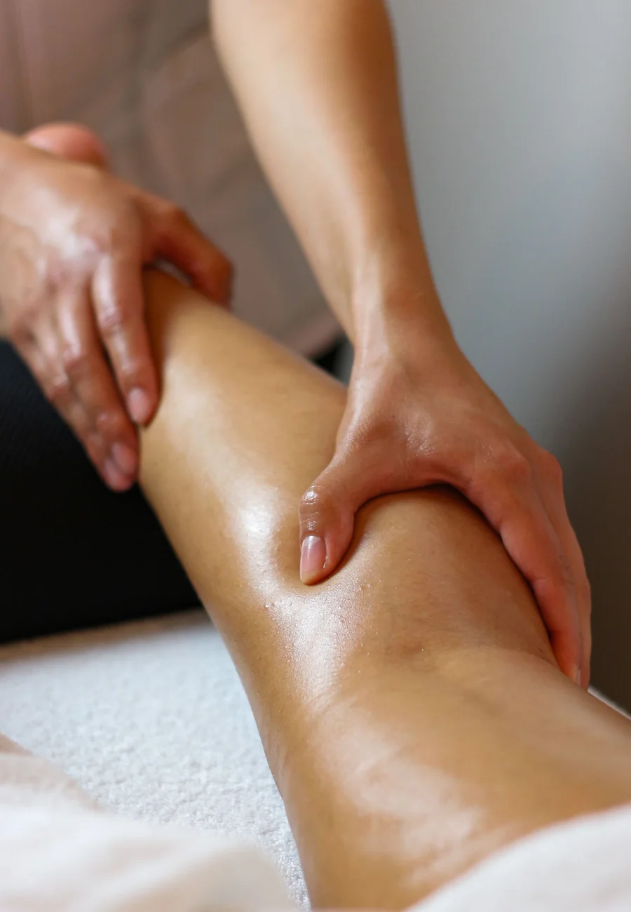 Professional therapist gently massaging a person's lower leg