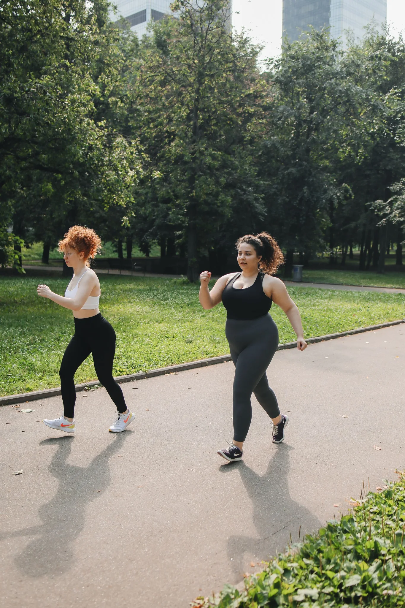 Two women brisk walking together on a park path
