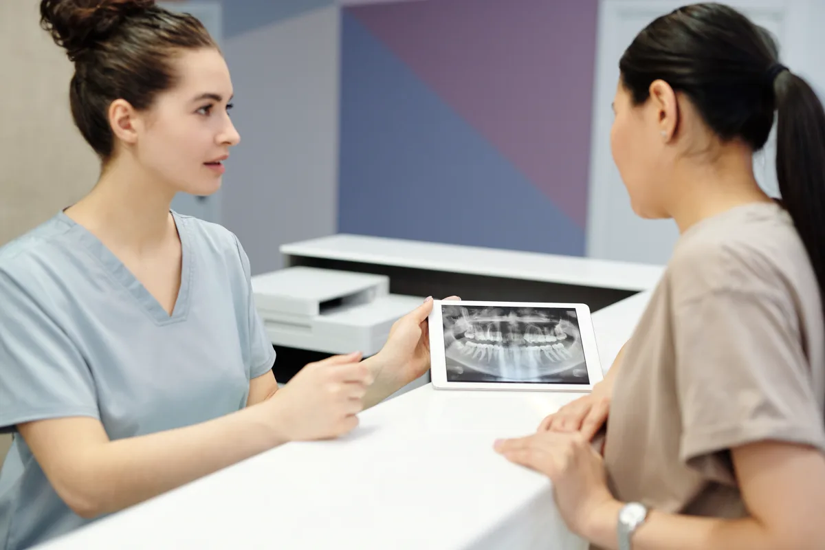 Dentist reviewing a dental X-ray with a patient during a consultation