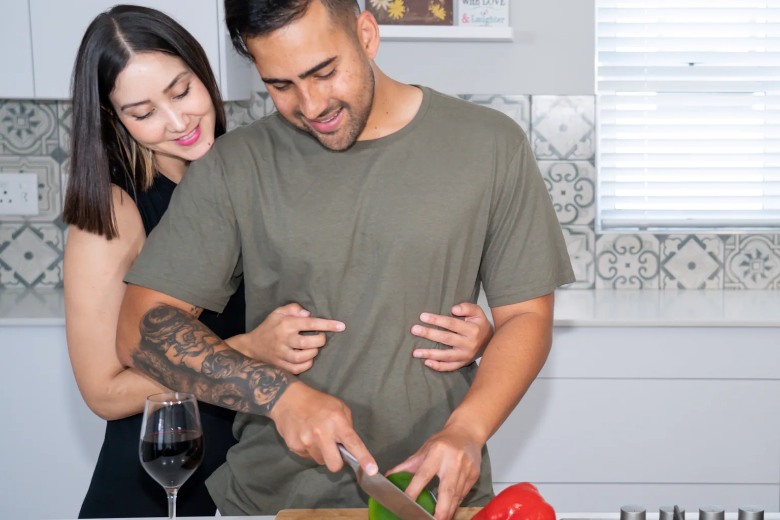 Married couple sharing affection while preparing vegetables together in their kitchen