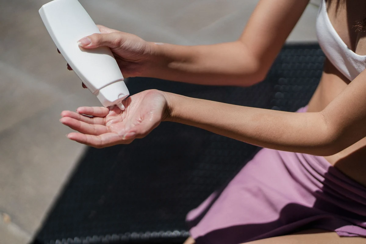 Woman dispensing sunscreen into her palm before outdoor exposure