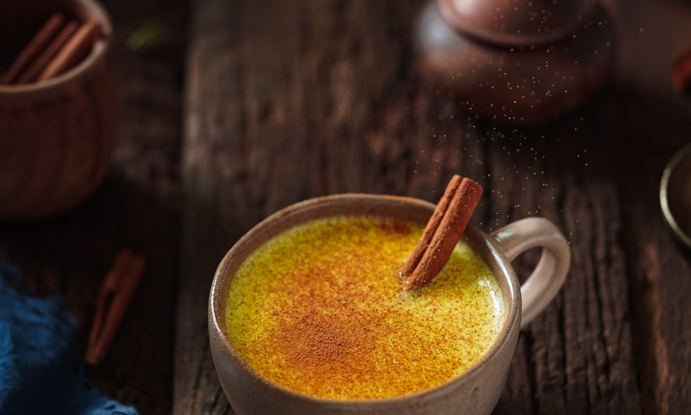 A minimalist, aesthetic mug of warm golden milk on a bright kitchen counter.